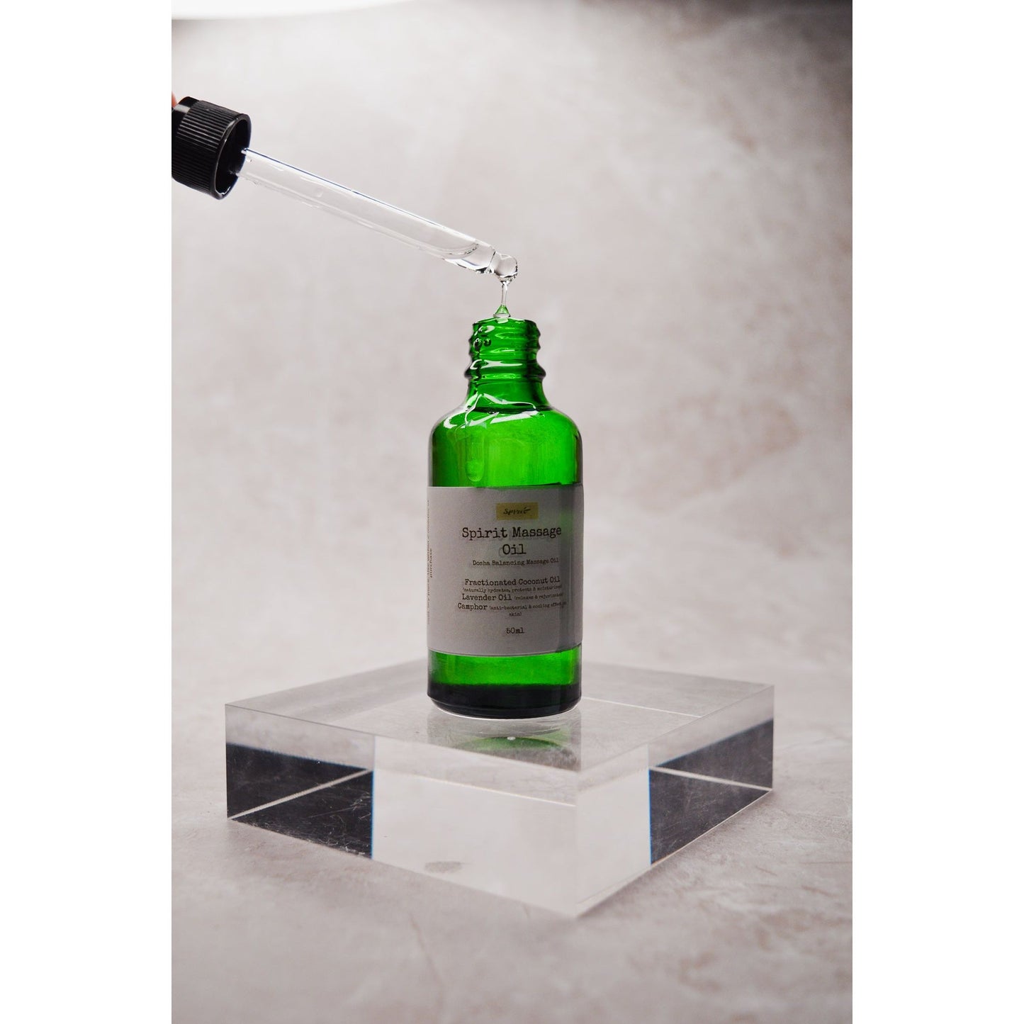 Spirit Massage Oil dripping from a dropper. Body & Massage Oil. Best Massage Oil in a green bottle.